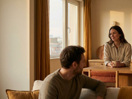 Man and woman sitting across from each other in a warm home setting having a calm and meaningful conversation