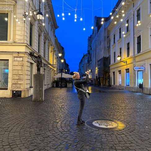 Die künstliche Beleuchtung zur blauen Stunde lädt eine Frau zum Fotografieren ein