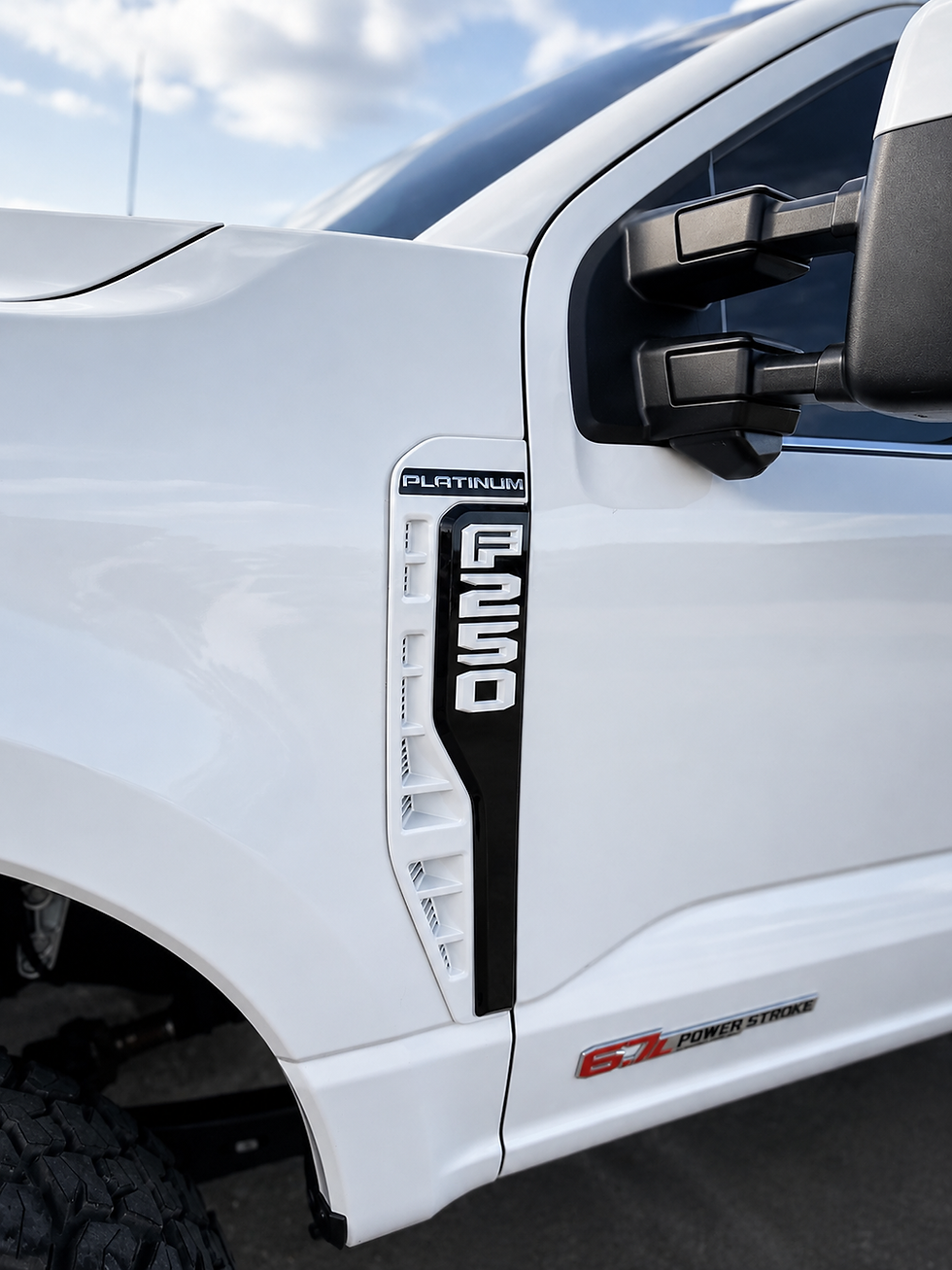 Color-matched Ford emblem and fender vent installed on a white F-250 Platinum