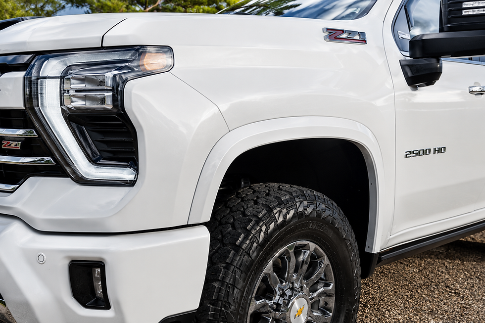 Color-matched front fender flare installed on a white Chevrolet Silverado 2500HD