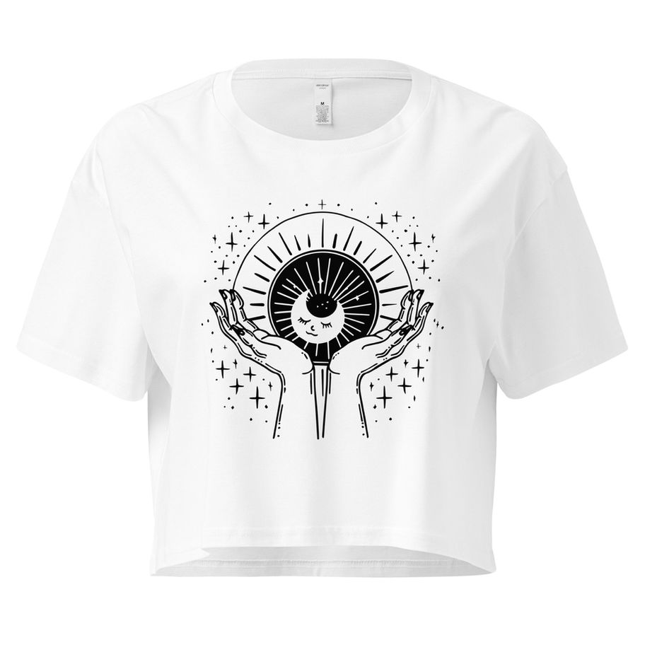 white  women’s crop top with black celestial hands holding a moon and eye graphic with stars and rays