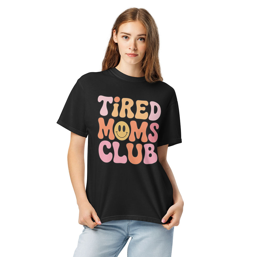 “Tired Moms Club graphic t-shirt in solid black, featuring a wavy retro 70s typography design with a small yellow smiley face