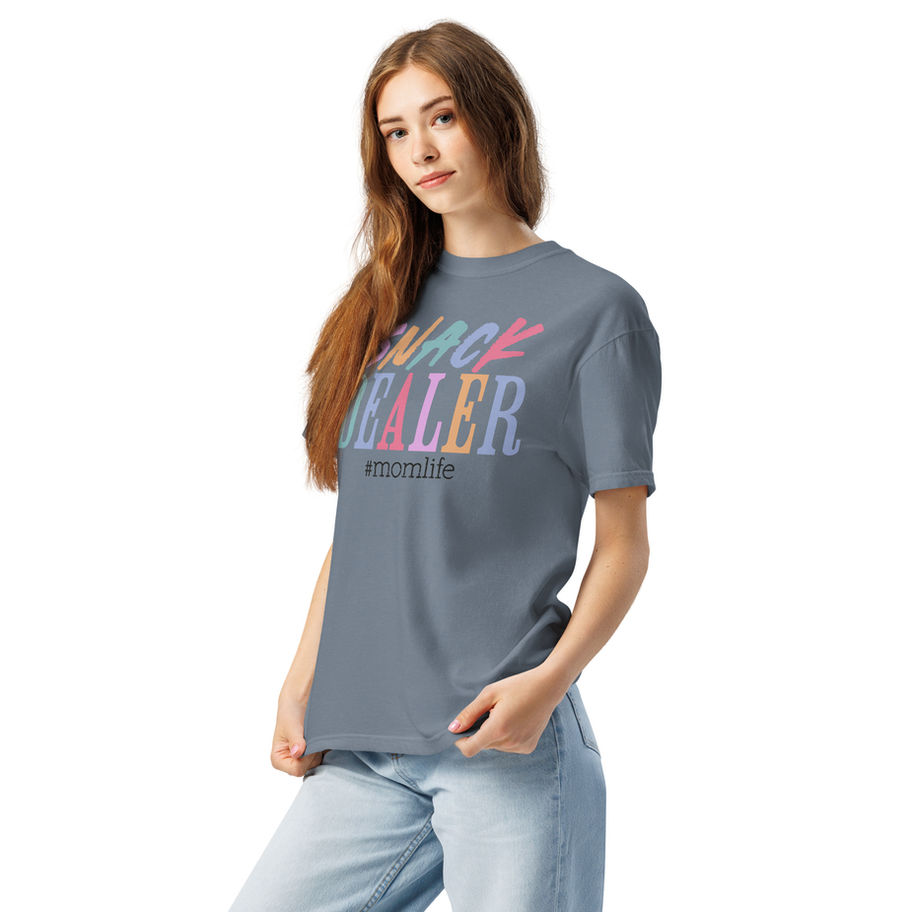 “Snack Dealer graphic t-shirt in white, featuring a wavy, distressed retro 70s typography design in pastel shades of pink, mi