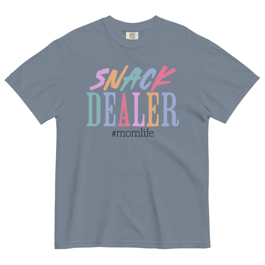 “Snack Dealer graphic t-shirt in white, featuring a wavy, distressed retro 70s typography design in pastel shades of pink, mi