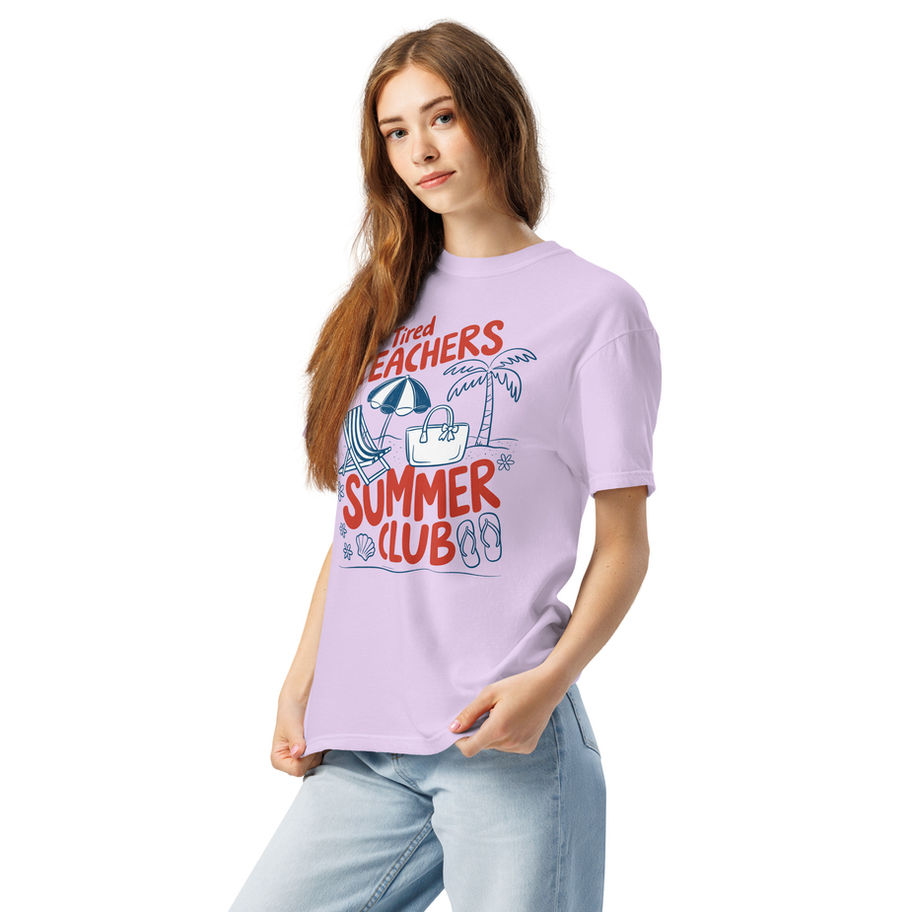 Light purple graphic t-shirt with “Tired Teachers Summer Club” summer themed design featuring playful school and beach icons