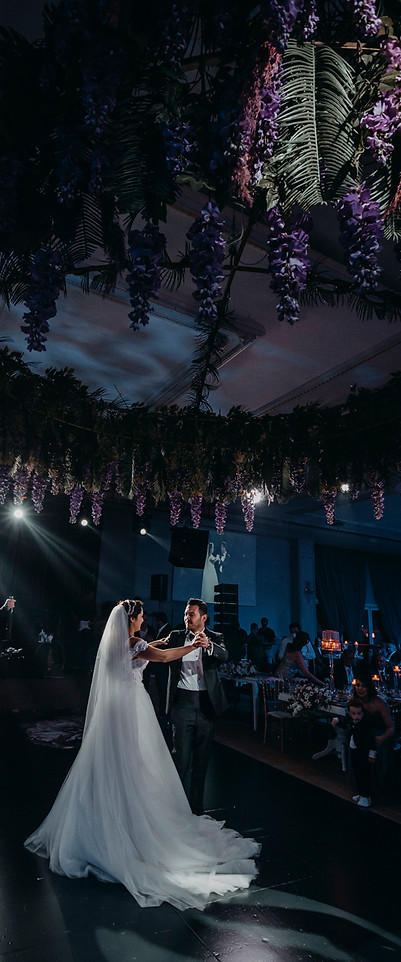 A magical first dance beneath a purple wisteria ceiling, as the bride and groom twirl in each other's arms.