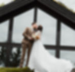 Newly wed couple kissing in front of a building