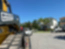 Skid Steer machine being hauled by landscaping company.