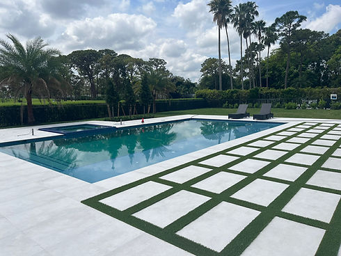 Back yard pool area with artificial turf inlay in patio.