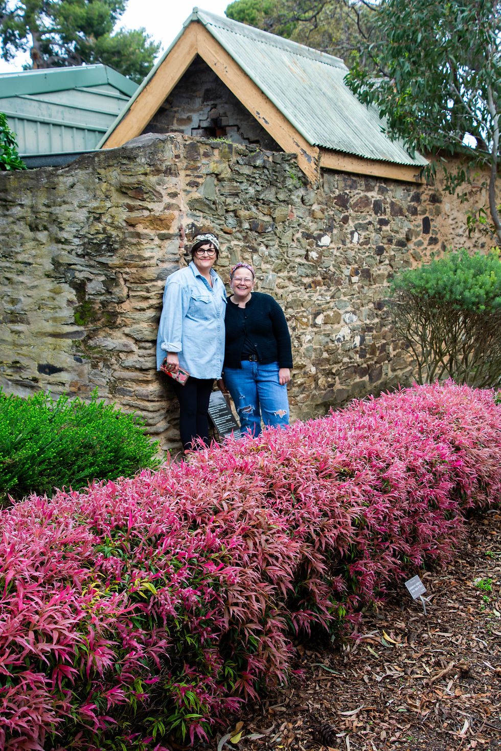 two women standing against a historical building in Adelaide Botanic Gardens