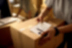 closeup-courier-attaching-address-label-package-while-working-office.jpg