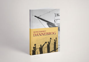 Kongeskibet Dannebrog katalog, står oprejst, man kan se forsiden på kataloget, hvor der er en gul boks med matroser der står med deres hatte i hånden, på baggrunden er der et sort-hvid billede af kongeskibets stævn.