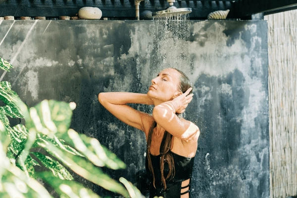 Lady taking a shower using Sacred Skin botanicals Love your Body Ritual Collection