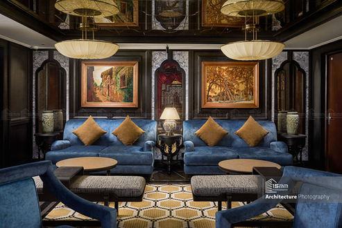 Khu lounge tiếp khách sang trọng với sofa xanh và ánh sáng ấm trong khách sạn boutique tại Hà Nội.
