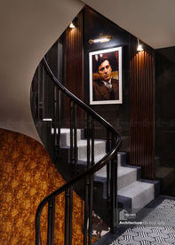 Elegant staircase with portrait artwork in luxury boutique hotel interior Hanoi