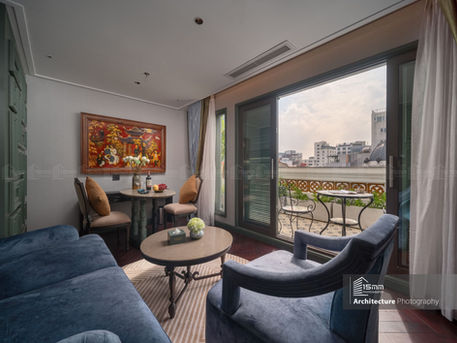 Không gian phòng khách trong suite khách sạn Tonkin Luxury Boutique Hotel Hà Nội với cửa ra ban công