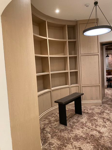 a curved shelf with a bench in front of it
