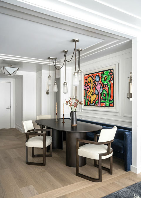 a dining room with a table and chairs and a painting on the wall