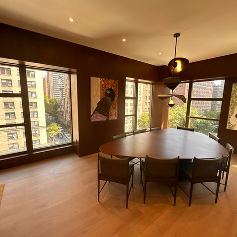 a room with a table and chairs and a painting of a bird on the wall