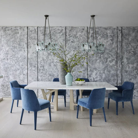 a dining room with blue chairs and a white table