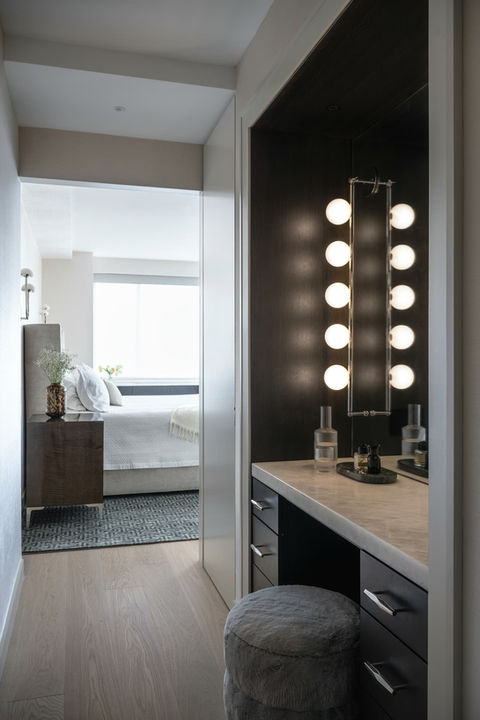 a bedroom with a vanity and a mirror