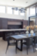 Pre post post work. This image shows a open plan dark kitchen and dinning room.