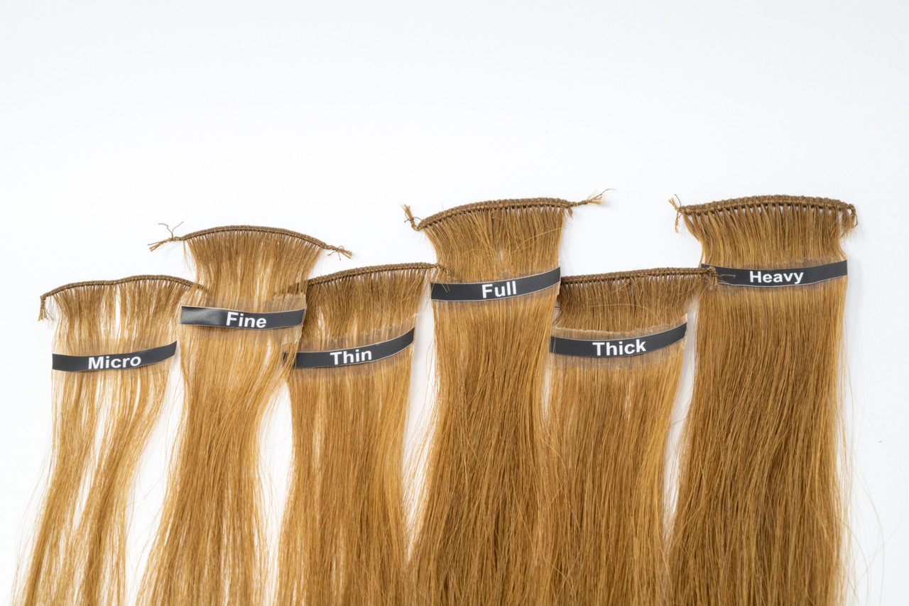 A linear display of six Gold Class hand-tied weft samples laid flat against a white background, labelled Micro, Fine, Thin, Full, Thick, and Heavy to show increasing density and volume.