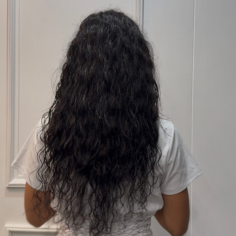 After curly hair extensions back view with added length and volume using 50cm natural curly hair, seamless blend