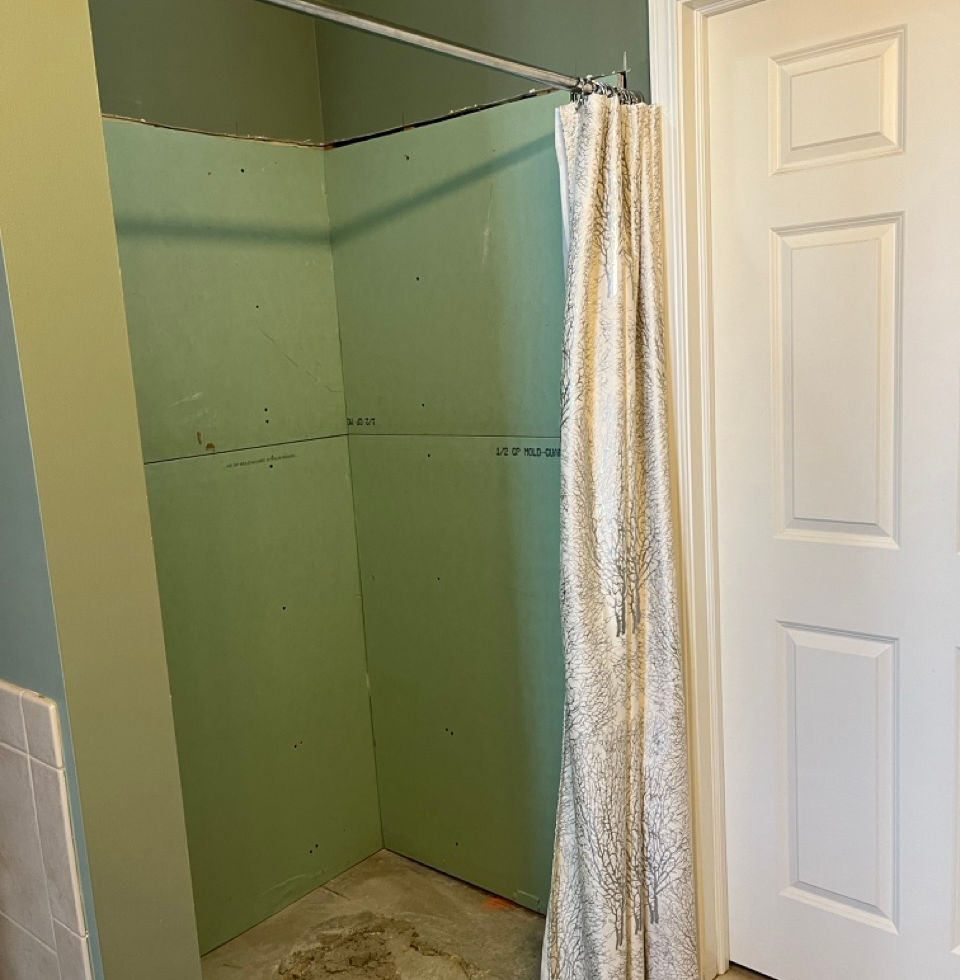 This was a shower stall with a leaky drain. Another contractor tore out the shower walls and pan and rerouted the drain. Left job unfinished.