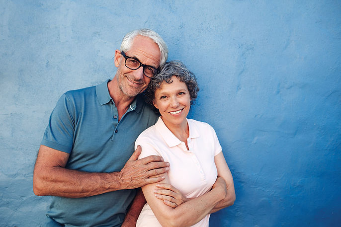 Smiling Happy Couple against a Blue Wall