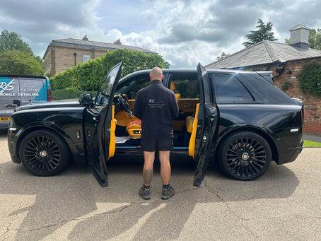 RS Valeting detailer in front of a Rolls Royce Cullinan with the RS Valeting Van behind