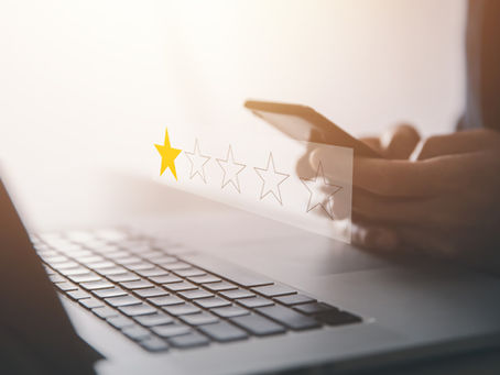 1 Star review hologram with laptop and person on their phone in the background