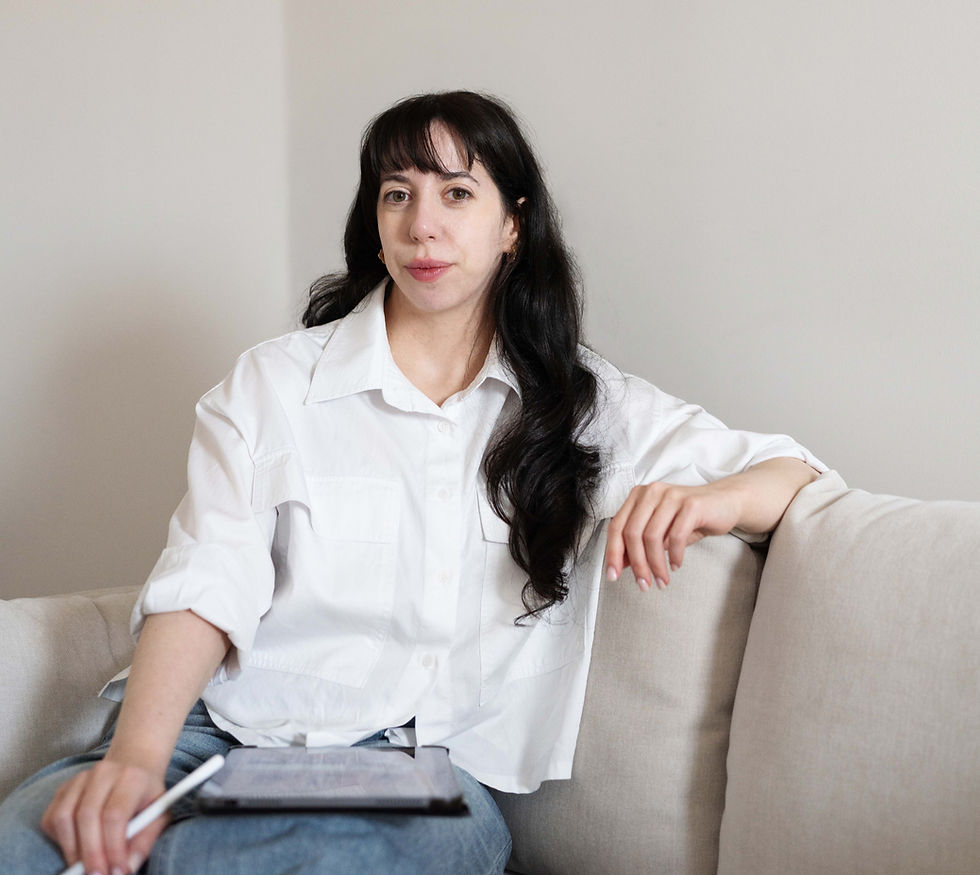 Beverley from Coached by Beverley sitting on a couch, holding a pen and ipad