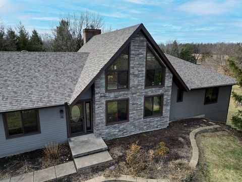 Large modern home with roofing, siding, and windows replaced and installed by Copper Creek Contractors of Central Illinois.