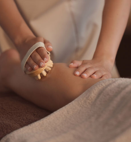 Beautiful young woman receiving massage with brush in spa salon.jpg