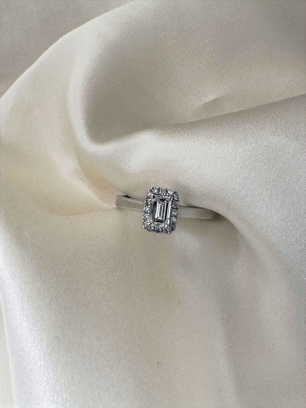 Thumbnail: 18K White Gold Ring with Emerald Cut Center Diamond and Side Diamonds

An elegant 18K white gold ring featuring a striking emerald cut center diamond, complemented by carefully set side diamonds that enhance its brilliance and sophistication. The clean lines of the emerald cut offer a refined, timeless aesthetic, while the additional diamonds add extra sparkle and balance to the design.

A perfect choice for an engagement ring, anniversary gift, or a statement piece, combining classic luxury with modern elegance.