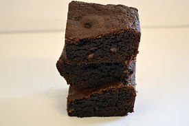 Stack of baked, square slices of chocolate brownies with chocolate chips