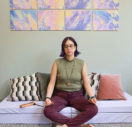 Dr. Stephanie sits in a meditative posture. Her eyes are closed and her face is calm.