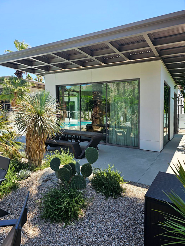 Modern outdoor living space with pool views on a sunny day.