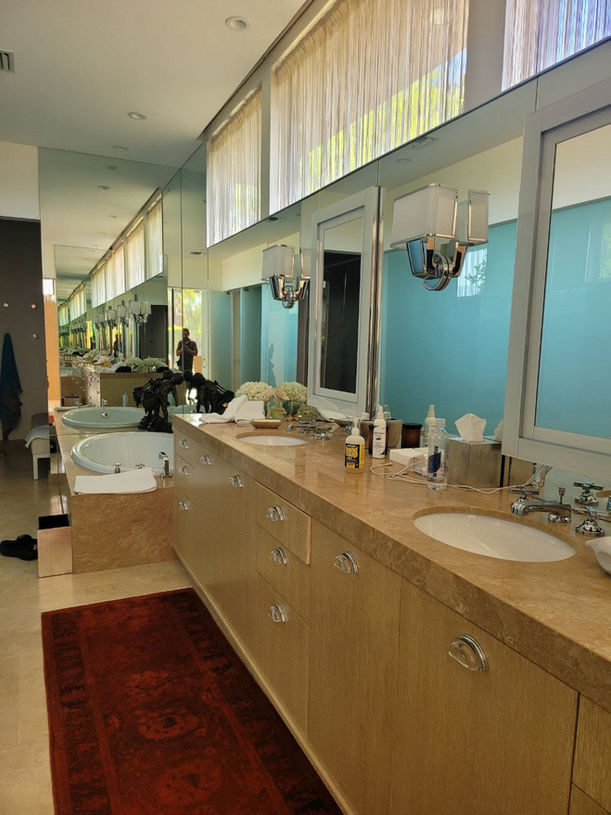 Elegant bathroom with long vanity, mirrors, and a luxurious red carpet