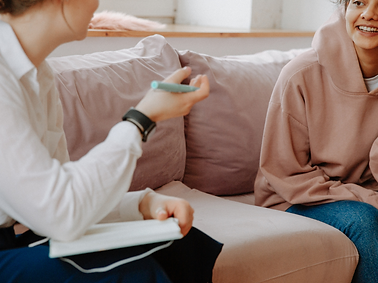 This image is of two young people sitting on a couch in a counselling session. 