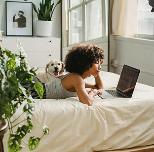 an adult laying in bed with her laptop