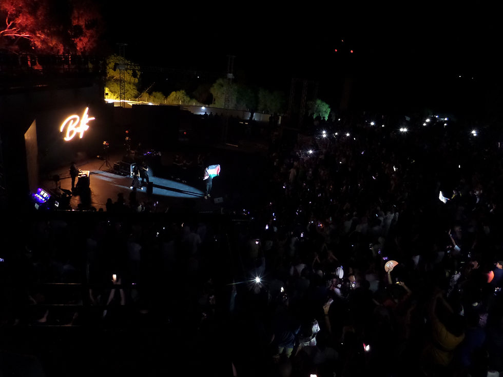 Le vétéran du rap tunisien, Mohamed Salah Balti, au milieu de sa quarantaine, est monté sur scène avec vingt minutes de retard lors de la 59 édition du Festival de Hammamet. Vingt petites minutes qui ont semblé longues dans la brume des projecteurs. Mais quand cet artiste charismatique est apparu, la foule — immense, brassée d’âges et de visages — a tout oublié. Il fut accompagné de jeunes danseuses et danseurs qui mettaient en chorégraphie dansée les mélodies de ses chansons. Oui, mélodies, même s'il y avait un DJ et pas un chef d'orchestre et des instruments. C'est bien ceci la musique dite moderne.