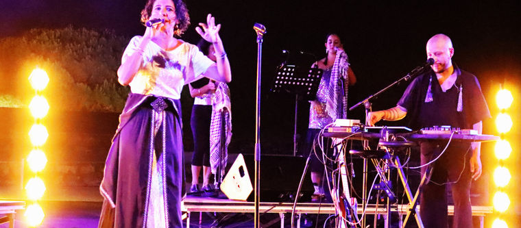 Ce duo avec leur troupe offre une alchimie captivante sur scène et une sonorité à la fois sombre et pleine d'espoir qui invite à se débarrasser des illusions et des utopies que nous poursuivons tout au long de notre vie. "Aïta" (ou ‘ayta) se traduit par "cri" ou "appel". Ce terme saisit idéalement le caractère du style criard des chikhates (ou chikhât, ou cheikhat), artistes et compagnes, qui jadis relayait les nouvelles majeures à travers leurs mélodies, voyageant de village en village avec leurs troupes. Dans la culture marocaine, l'aïta est d'usage dans les fêtes de mariage et les différentes célébrations, surtout dans les milieux ruraux de ce pays.