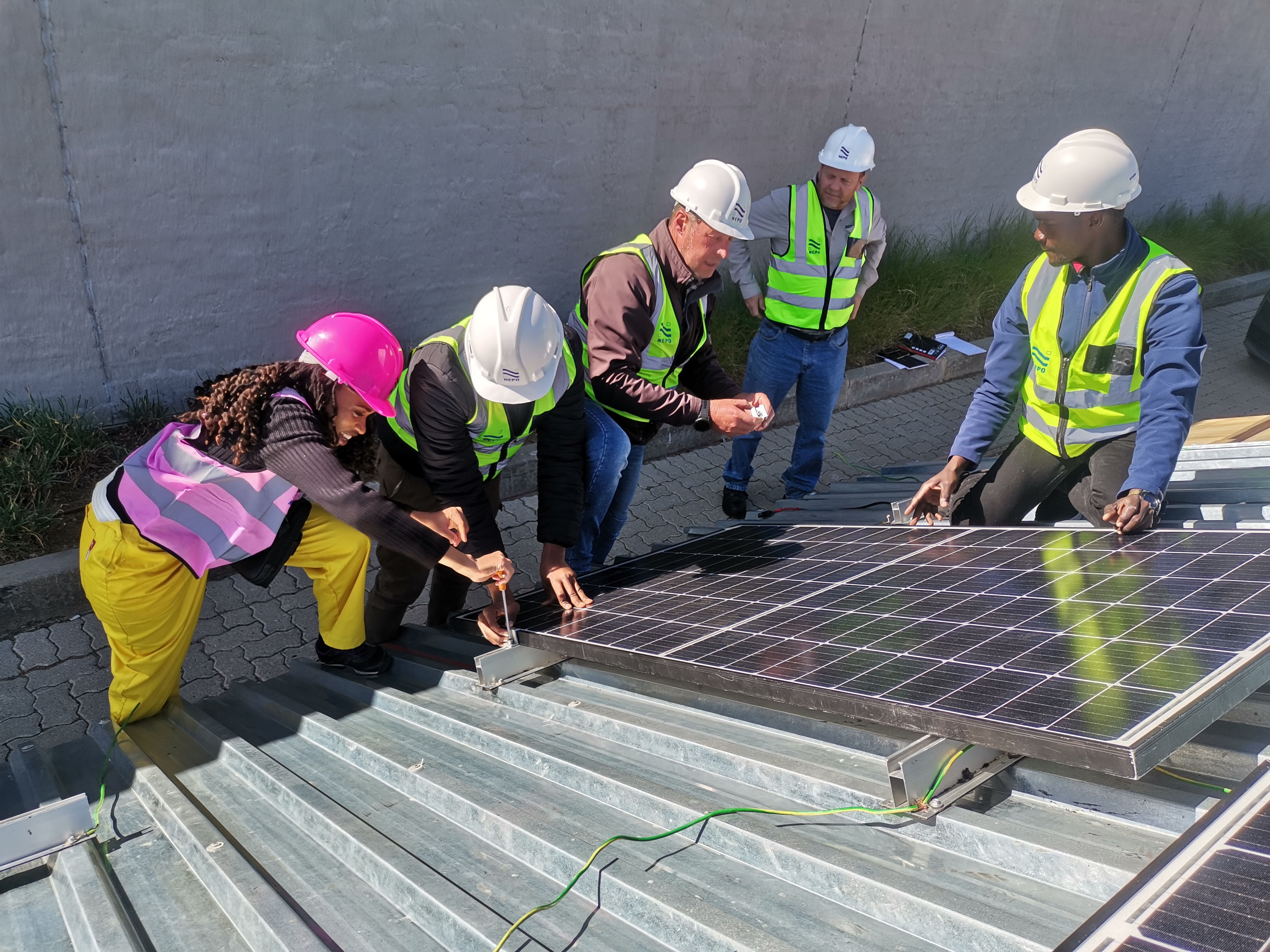 Image of our students mounting solar panels at our campus in Cape Town