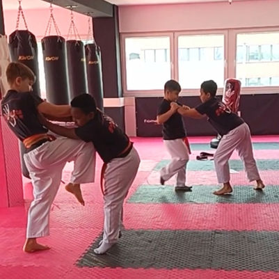 Kind führt Kniestoß in der Partnerübung aus, Im Krav Maga Kindertraining in der 360° FIGHTNESS ACADEMY Filderstadt