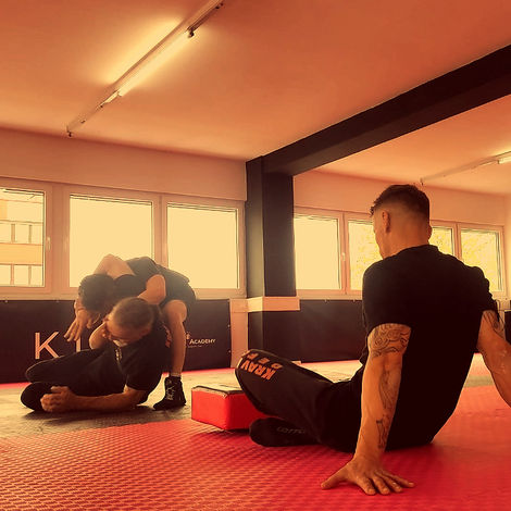 Zwei Teilnehmer bei einer Krav Maga-Prüfung, sie demonstrieren eine Übung vor einem Prüfungsleiter