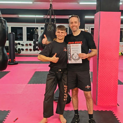 Krav Maga Trainer Steffen hält stolz seine Urkunde für die bestandene Basic 5 Prüfung Verteidigung gegen Waffen in der 360° FIGHTNESS ACADEMY Filderstadt