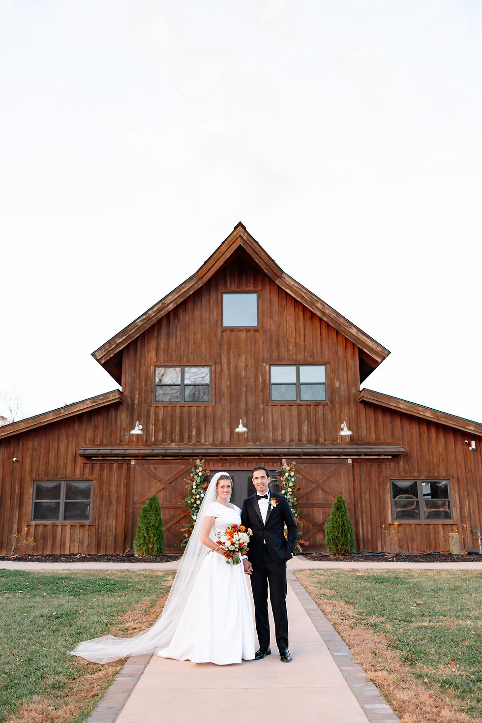 Bride and groom in front of the barn at Pleasant Grove Farm, a wedding venue in northwest Charlotte NC