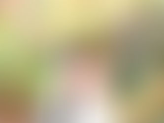 Couple embraces on a forest path in autumn. Woman smiles in white dress; man holds her lovingly. Vibrant foliage surrounds them. Charlotte Engagement Photos by Aubrey Elizabeth Photography